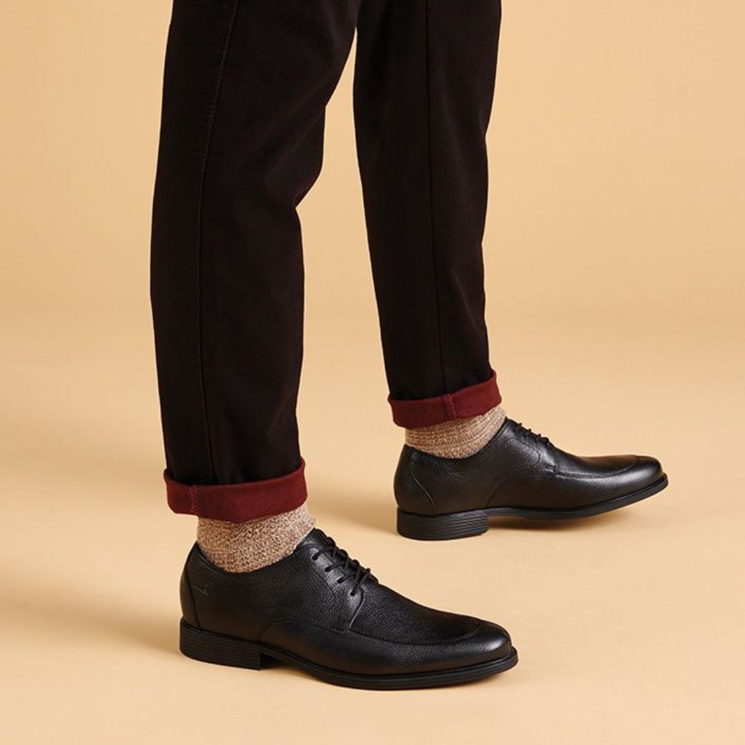 Man with black jeans and knit socks wearing the Whiddon Apron dress shoe. 