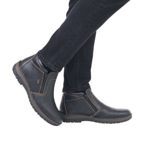 05173 Double Zip Boot shown in black leather with contrasting stitching, featuring dual side zippers, ankle height design, and rugged rubber sole, styled with dark jeans to showcase casual winter wear functionality