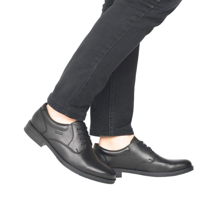 10304 Laced Dress Shoe shown on feet wearing dark jeans, displaying classic black leather oxford design with sleek silhouette, lace-up closure, and durable rubber sole for professional styling