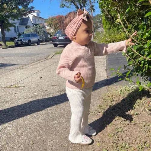 Toddler wearing Robeez Soft Sole Shoes - Reach for the Stars in a casual outdoor setting. Shoes feature a thin suede sole for healthy foot development.