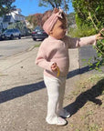 Toddler wearing Robeez Soft Sole Shoes - Reach for the Stars in a casual outdoor setting. Shoes feature a thin suede sole for healthy foot development.