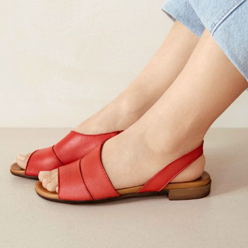 Woman wearing Tansing sandals in red. 