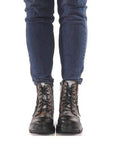 Front view of L'Artiste combat Boot worn with jeans, showcasing lace-up design and rugged platform sole.