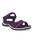 An Ecco walking sandal with purple uppers with textured accents and black lining, a velcro heel, instep and toe straps. The midsole is white with a black outsole.