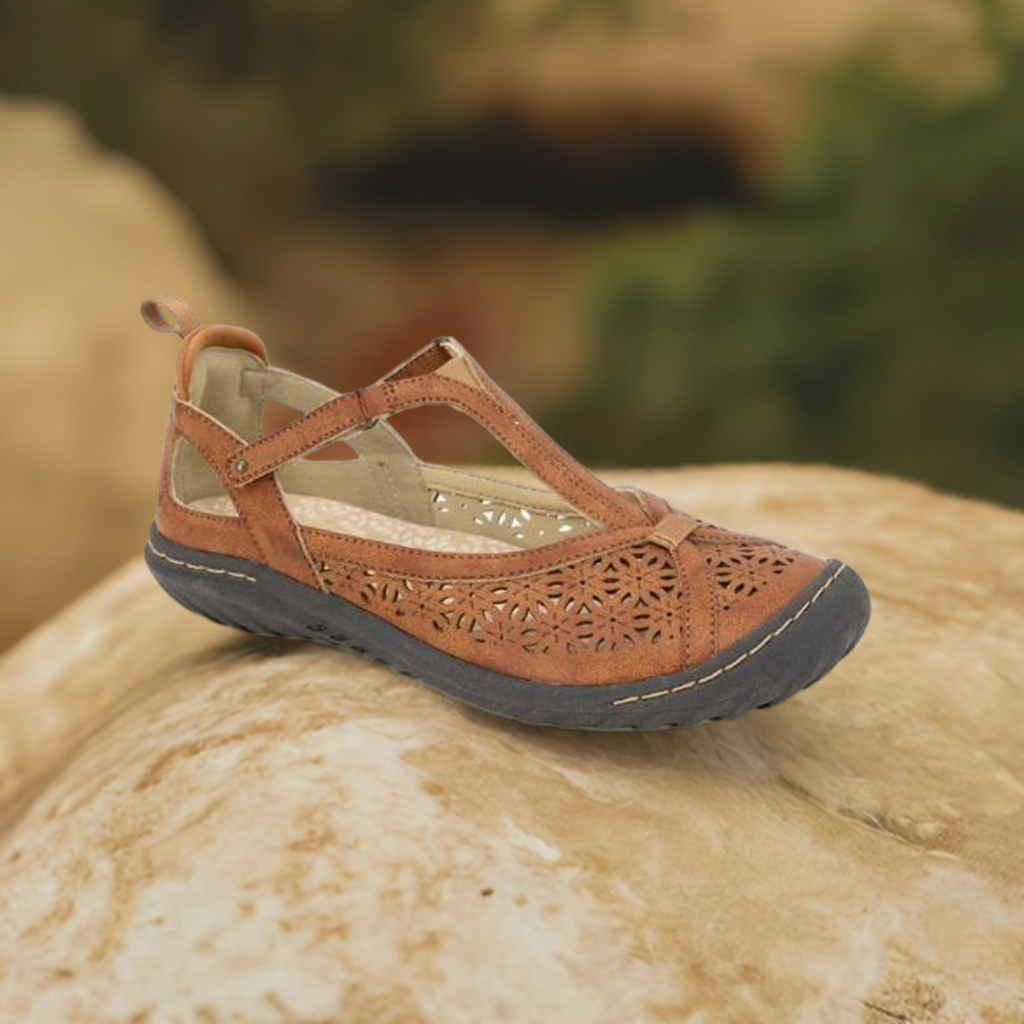 Brown Mary-Jane Flat by on rocky surface against a blurred natural background.