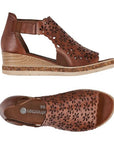 Pair of brown leather wedge sandal with floral cut-outs and velcro ankle strap.