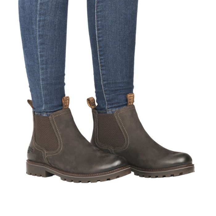 Legs in cuffed jeans wearing brown Chelsea boot with dark brown elastic goring.