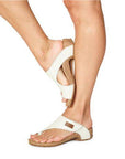 Model wearing the Taos Loop Sandal in white, demonstrating its comfortable fit and stylish toe ring design.