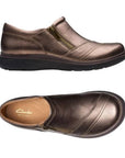 Top and profile of Bronze slip on shoe with detailed overlap upper featuring side zipper and black durable outsole. Tan footbed with gold Clarks logo