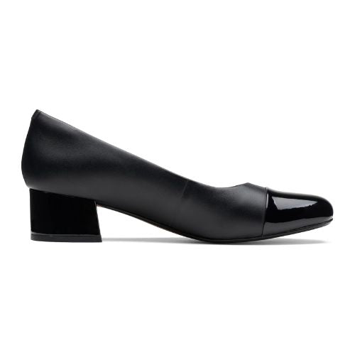 Profile view of black leather pump with patent heel and toe. 