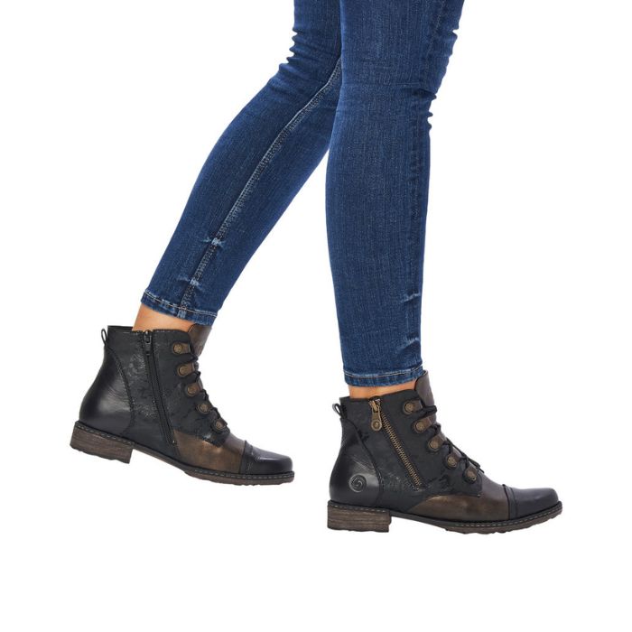 Legs in jeans black and bronze ankle boto with lace closure.