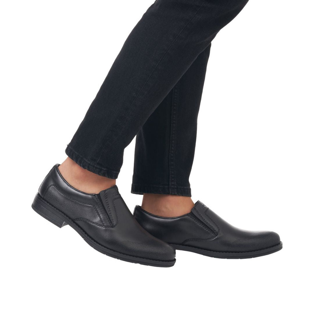 10350 Dress Loafer in classic black leather shown on feet with dark jeans, featuring sleek slip-on design with elastic goring sides, smooth leather upper, and durable rubber outsole for versatile formal to casual wear