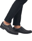 10350 Dress Loafer in classic black leather shown on feet with dark jeans, featuring sleek slip-on design with elastic goring sides, smooth leather upper, and durable rubber outsole for versatile formal to casual wear