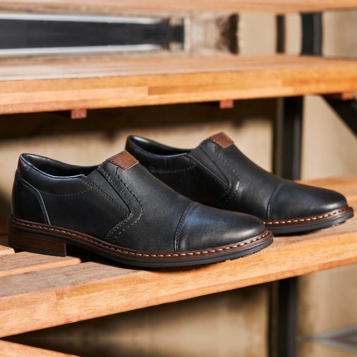 Black leather slip on shoe with toe cap.