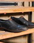 Black leather slip on shoe with toe cap.