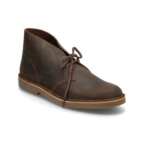 Beeswax brown desert boot with leather tag showing the Clark's logo and Desert Boot name. Dark brown laces, light brown outsole and tan stitching line between upper and outsole