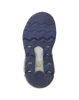 Bottom view of a navy blue shoe sole with zigzag tread and a flexible rubber outsole on a white background.