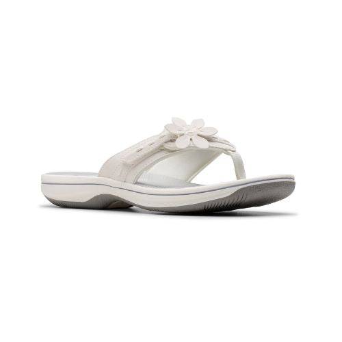 White thong sandal with white midsole, grey footbed with white designs including Clarks Cloudsteppers logo, fabric toe post, and adjustable white strap with white flower. Dark grey outsole with rocker bottom design.