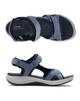 Profile and top view of Blue walking sandal with Velcro on heel, toe and ankle strapes. Dark blue lining with lighter blue on the upper for contrast look. Light grey thick midsole and black rocker rubber outsole. Dark blue footbed with light blue Clarks logo and wave like designs