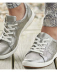 Model walking in the Caren 01 Sneakers in Platinum. 