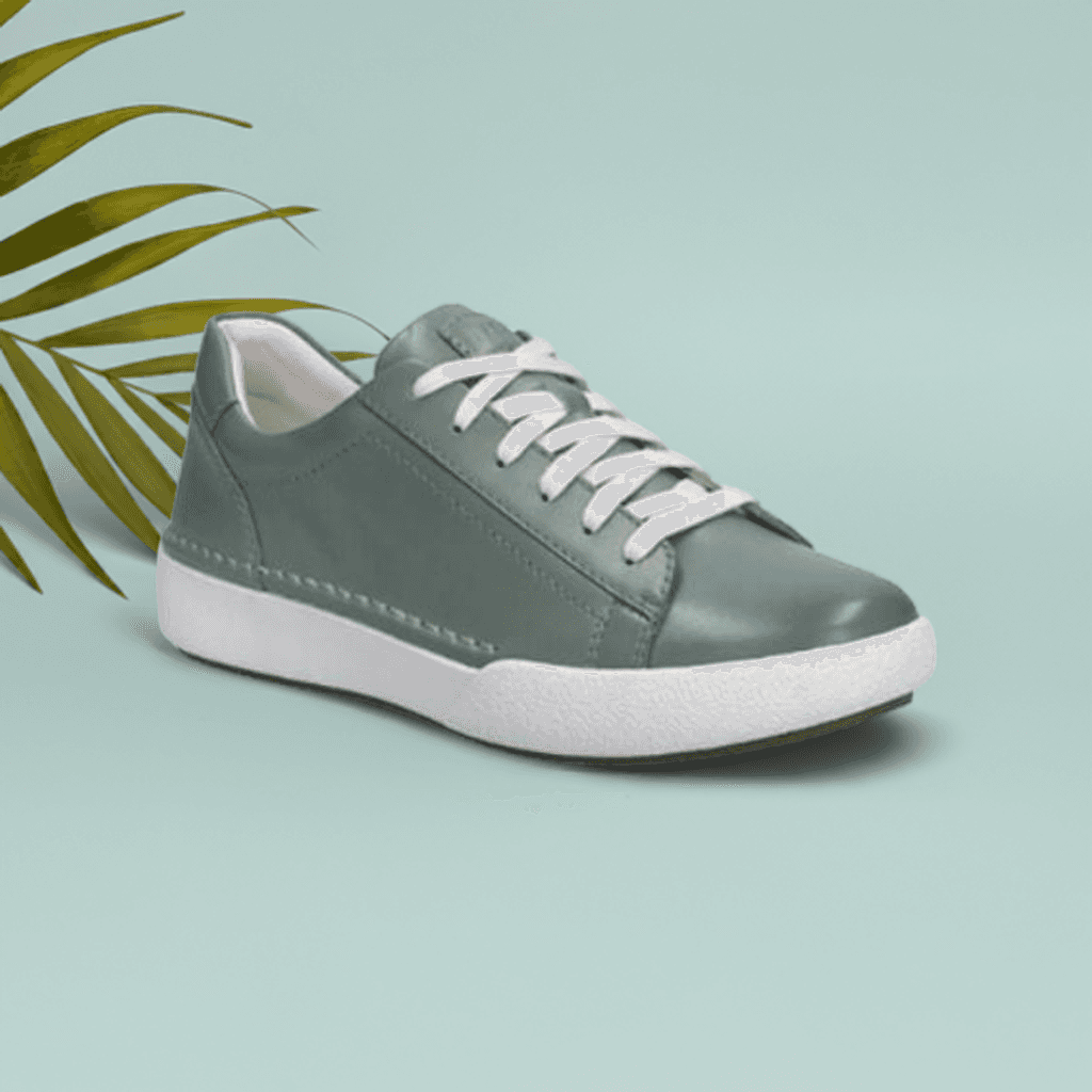 Sage green sneaker with white laces on a teal background featuring a leaf.