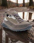 A pair of brown Ecco sneakers with Michelin outsole on a muddy puddle trail.