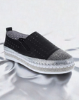 A Bernie Mev black leather sneaker with silver rhinestone details on silver rippled counter space.