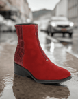 Bos & Co Jordon Zip Ankle Boot in red suede displayed outdoors on a rainy street, highlighting its waterproof and stylish design.