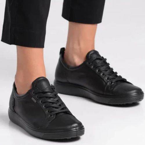 Ecco's all Black leather sneakers on a lady with black capris.