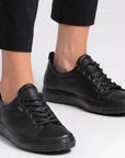 Ecco's all Black leather sneakers on a lady with black capris.