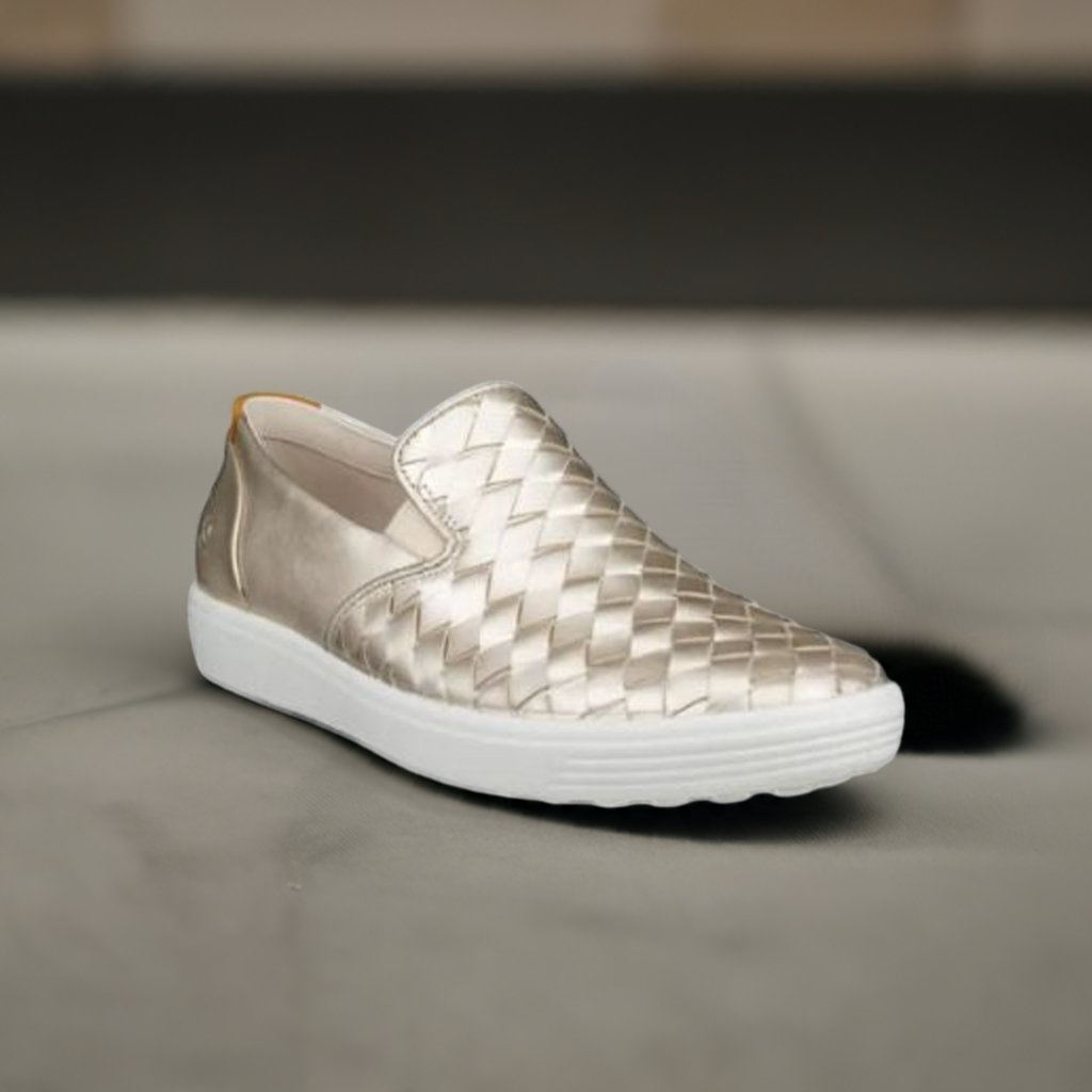 A gold leather slip on shoe with mix of woven and smooth leathers on a white outsole.