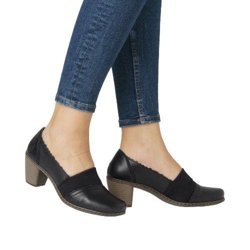 Women in jeans wearing black heeled leather and elastic shoe.