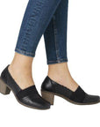 Women in jeans wearing black heeled leather and elastic shoe.