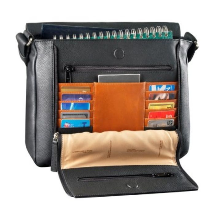 Interior of black handbag, revealing brown leather accents, multiple card holders, two zippered pockets, and space for a notebook. 