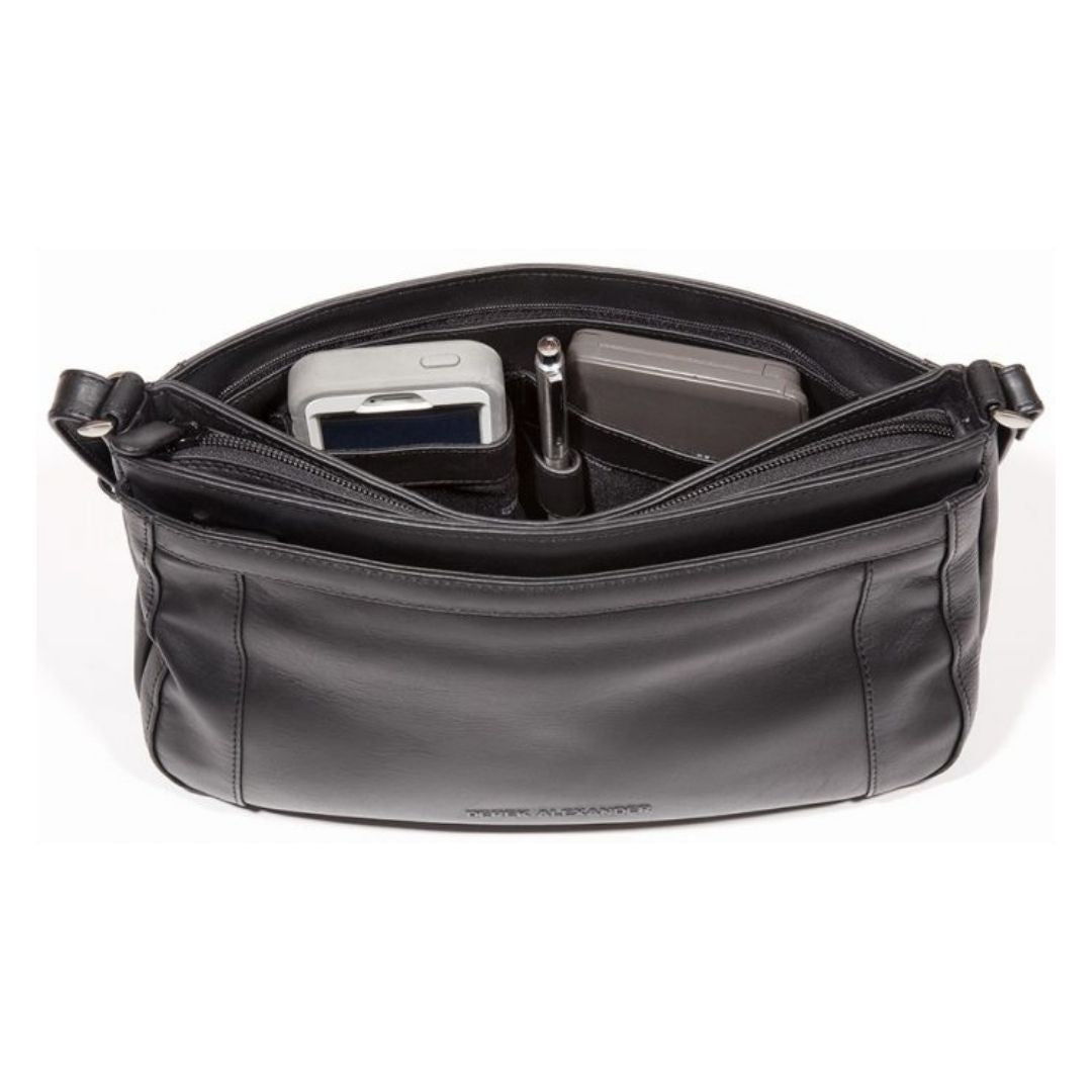 Inside view of black leather handbag with adjustable strap holding pen, wallet and cell phone.