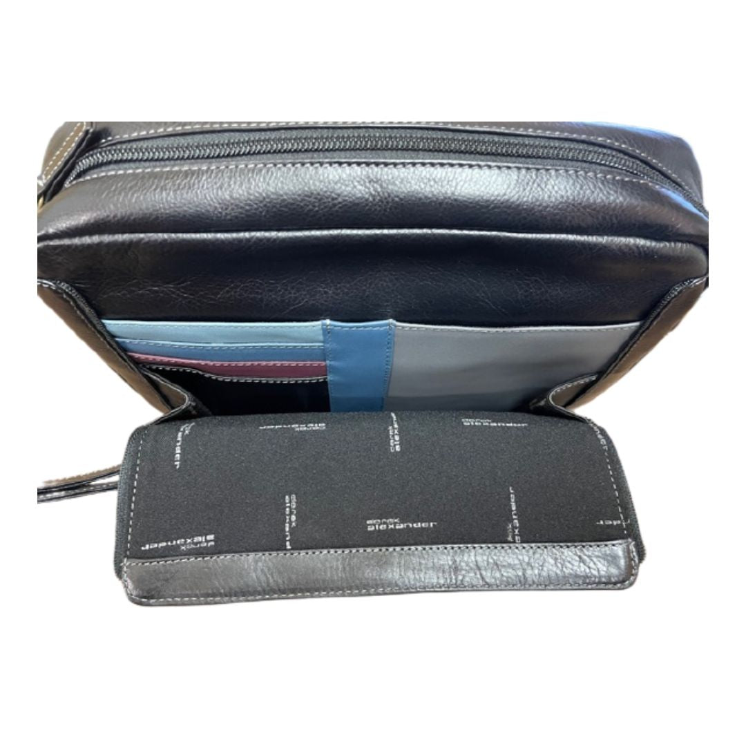 Interior of the front organizer compartment, revealing card slots, pen sleeve, and a slip pocket. Lining is black with blue, purple, teal, and grey leather accents. 