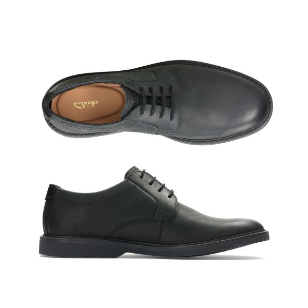 Top and side view of black leather dress shoe with laces and black outsole. Clarks logo on heel of insole.