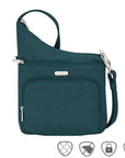 Teal crossbody bag with horizontal zippered pocket and zippered pouch pocket. Silver Travelon logo emblem on front.