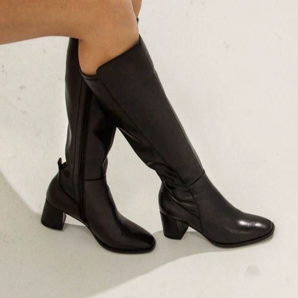 Women with crossed legs wearing the Josephine boot, which reaches just below the knee. 