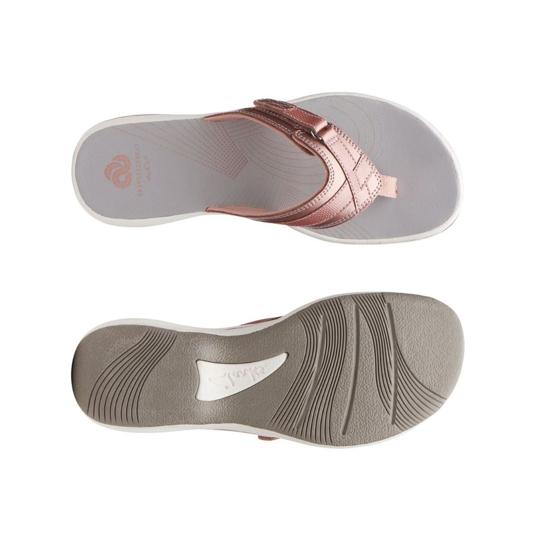 Top and bottom view of Breeze Sea sandal in rose gold. Clarks branding is visible on footbed and outsole. 