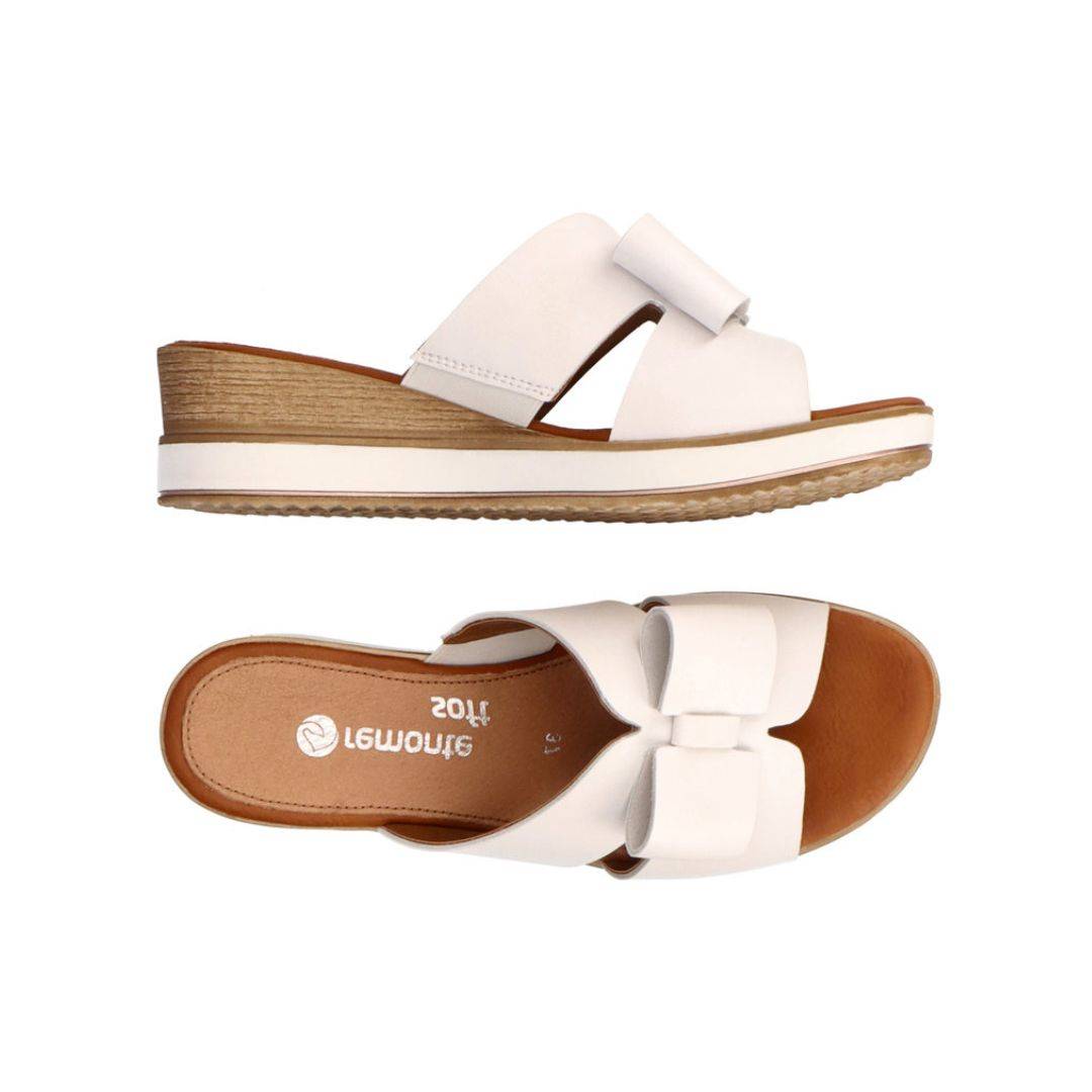 Top and side view of white leather slide wedge sandal with bow. Remonte logo on brown insole.