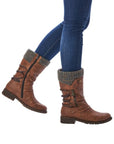 Legs in jeans wearing brown mid-height boot with knitted cuff and decorative outside zipper. Boots also have inside functinoal zipper.