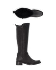 A pair of Rieker tall black leather boots, woven back side and black string wrapped around ankle with silver beads. It has a low black heel.