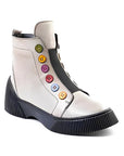 White leather ankle boots with black platform outsole. Multi-coloured buttons run up front of boot.