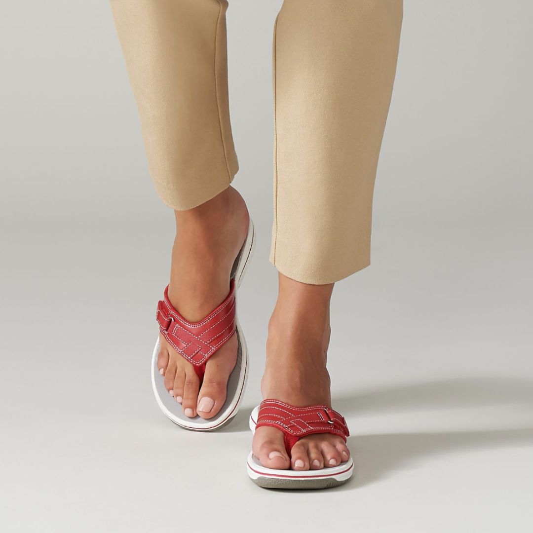 Woman walking wearing the Breeze Sea sandal in red. 