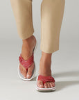 Woman walking wearing the Breeze Sea sandal in red. 