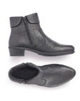 A pair of black Rieker ankle boots with  zipper, on both sides, folded down cuff, detailed stitching, and a low heel.