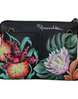 Rear exterior of black leather handbag with bronze hardware loops and a vibrant, hand painted floral pattern. 