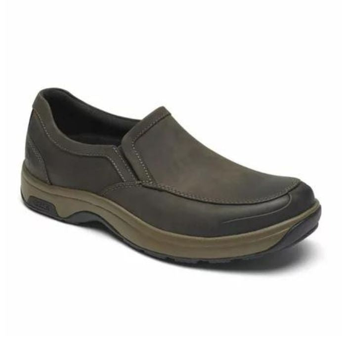 Battery Park in brown. Dark brown nubuck slip on shoe with apron toe stitching. Midsole is taupe, outsole is black. 